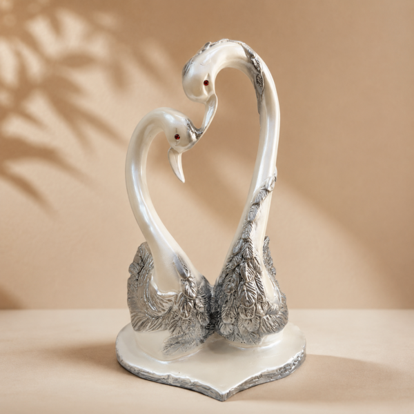 Shop an elegant Marble Dust Swan Couple Showpiece featuring pearl-white and silver detailing. A beautiful decorative figurine for home décor, weddings, anniversaries and gifting.
